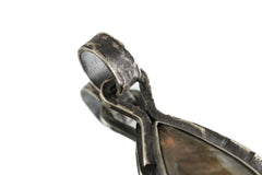 Close view of Aurora Veil Labradorite pendant showing oxidized silver frame and circular bail.