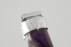 Close-up of tooth-shaped Amethyst Cabochon with organic textured sterling silver cap and signature triangle detail.