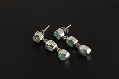 Blue Apatite geometric earrings displayed on a dark background, with three-stone sterling silver drop design.