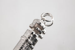 Close-up of sterling silver capsule pendant showing sand-textured surface, round bail, and opening mechanism.