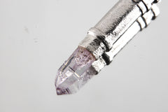 Close-up of sterling silver capsule pendant showing sand-textured surface, round bail, and opening mechanism.