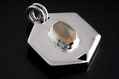 Ethiopian Opal sterling silver hexagon pendant shown on dark background with polished geometric frame.
