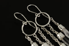 Close-up of Quartz Point dangle earrings showing fine sterling silver chains and hammered circle construction.