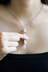 Vera Cruz Amethyst sterling silver capsule pendant worn on a model, with pale purple crystal point and polished silver locket.