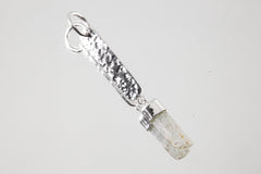 Ocean Clarity Aquamarine silver pendant shown on white background with hammered 925 sterling silver and raw crystal.