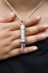 Vera Cruz Amethyst sterling silver capsule pendant worn on a model, with pale purple crystal point and polished silver locket.