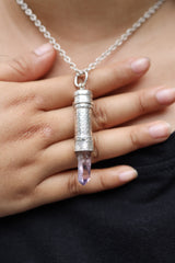 Vera Cruz Amethyst sterling silver capsule pendant worn on a model, with pale purple crystal point and polished silver locket.
