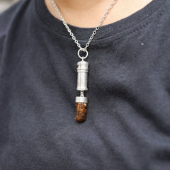 Brown Tourmaline Dravite capsule locket pendant shown worn on a model, with polished sterling silver and crystal point base.
