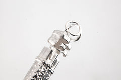 Close-up of sterling silver capsule pendant showing textured silver surface, round bail, and opening mechanism.