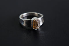 Brown Tourmaline Terminated Ring shown on black background with shiny hammered silver band and raw brown crystal.