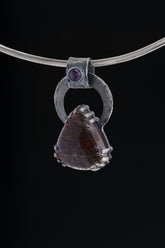 Gem Amethyst Black Rutile Quartz pendant displayed on silver choker against black background.
