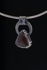 Gem Amethyst Black Rutile Quartz pendant displayed on silver choker against black background.