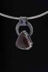 Gem Amethyst Black Rutile Quartz pendant displayed on silver choker against black background.