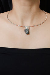 Green Tourmaline Stack Pendant shown worn on the chest with sterling silver cap and raw green crystal.