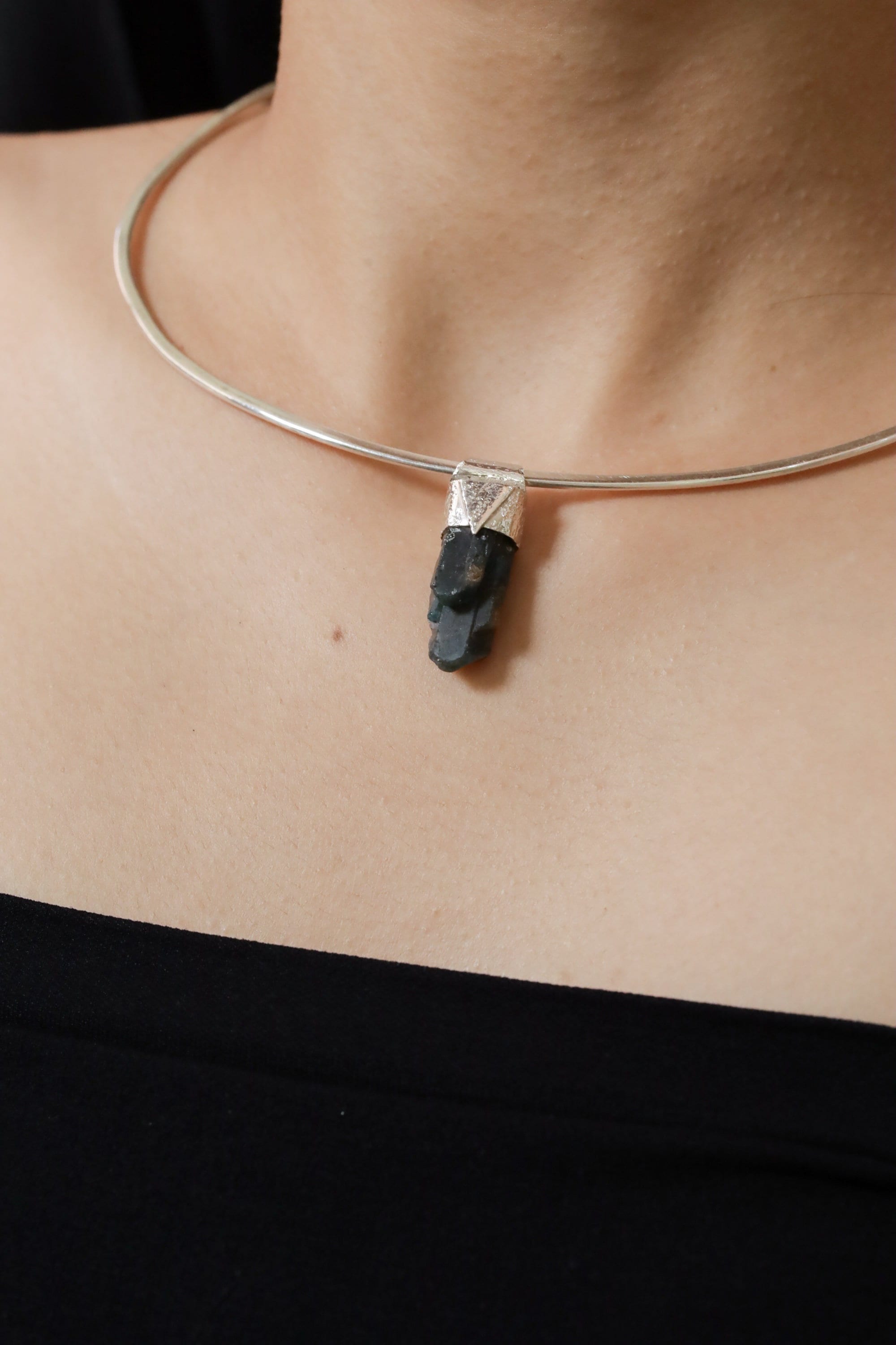 Blue Gem Apatite Stack Pendant shown worn on the chest with sterling silver cap and vivid blue-green crystal.