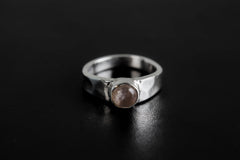 Eternal Rose Quartz Hammered Ring shown on black background with soft pink gemstone and polished silver band.