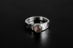 Eternal Rose Quartz Hammered Ring shown on black background with soft pink gemstone and polished silver band.