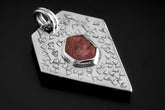 Geometric Ruby pentagon pendant in oxidized 925 sterling silver, shown on black with abstract texture and central red stone.