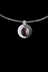Ruby Cabochon pendant shown on black cord, with polished 925 sterling silver circular moon face and crescent border texture.