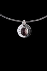Ruby Cabochon pendant shown on black cord, with polished 925 sterling silver circular moon face and crescent border texture.