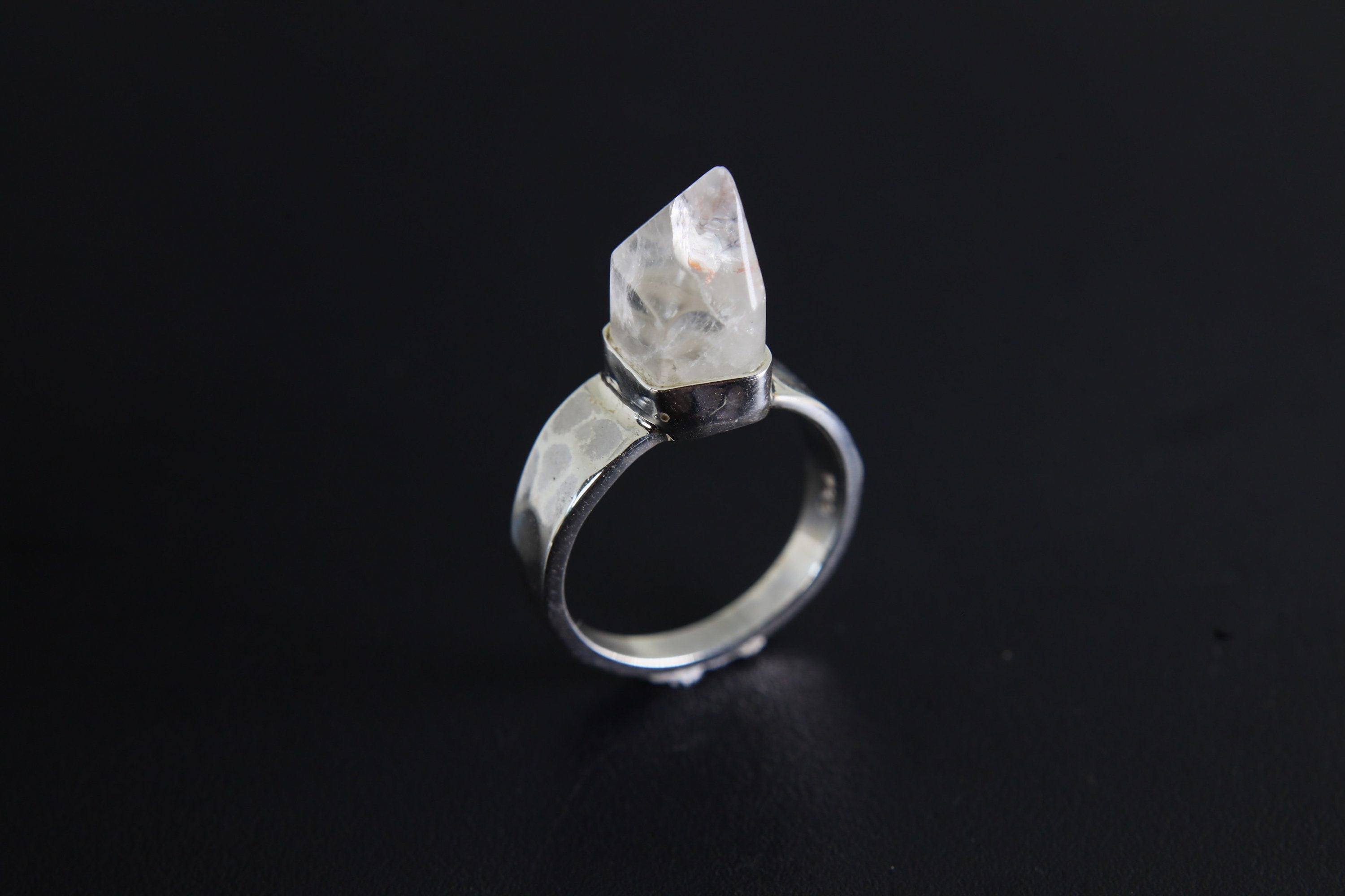 Handmade 925 sterling silver Cacoxenite Quartz point ring shown on a dark background, with clear crystal point and hammered band.