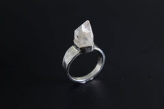 Handmade 925 sterling silver Cacoxenite Quartz point ring shown on a dark background, with clear crystal point and hammered band.