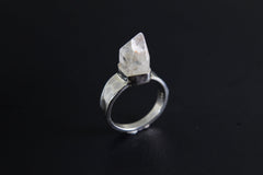 Handmade 925 sterling silver Cacoxenite Quartz point ring shown on a dark background, with clear crystal point and hammered band.