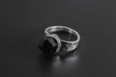 Side view of handmade Black Tourmaline ring showing the raised raw stone, bezel setting, and polished silver band.