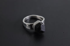 Handmade 925 sterling silver Black Tourmaline ring shown on a dark background, with raw black crystal and hammered silver band.