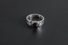 Side view of handmade Black Tourmaline ring showing the raised raw stone, bezel setting, and polished silver band.