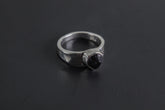 Handmade 925 sterling silver Black Tourmaline ring shown on a dark background, with raw black crystal and hammered silver band.