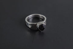 Handmade 925 sterling silver Black Tourmaline ring shown on a dark background, with raw black crystal and hammered silver band.