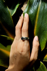 Black Tourmaline ring shown worn on the hand, with raw black crystal and shiny hammered sterling silver band.