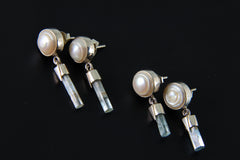South Sea Pearl Aquamarine earrings shown worn on the model, with luminous pearl tops and pale blue raw crystal drops.