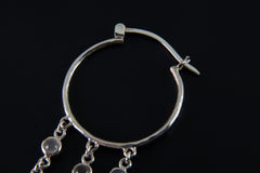 Detailed view of large Moonstone hoop earring showing sterling silver hoop fitting and dangling gemstone chains.