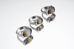 Oval Labradorite Oxidized Silver Ring shown on white background with wide hammered sterling silver band and flashing gemstone.