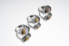 Oval Labradorite Oxidized Silver Ring shown on white background with wide hammered sterling silver band and flashing gemstone.
