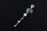 Turquoise Moonstone orbital pendant shown on a dark background, with polished sterling silver and three dangling Moonstones.