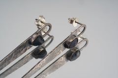 Close view of oxidized Sapphire earrings showing hammered 925 sterling silver texture and deep blue gemstone studs.