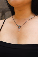 Vera Cruz Amethyst Ethiopian Opal Pendant shown worn on the chest with oxidized sterling silver and vertical Amethyst crystal.