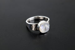 Radiant Blue Moonstone Hammered Ring shown on black background with round Moonstone and shiny hammered silver bezel.