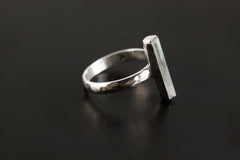 Side view of long square cut Aquamarine ring showing hammered sterling silver band and slim vertical gemstone setting.