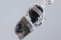 Black Tourmaline Watermelon Tourmaline pendant shown on a white background with handmade two-stone sterling silver setting.