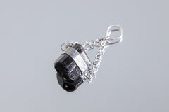 Black Tourmaline Eclipse pendant shown on white background with handmade sterling silver setting and chain.