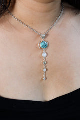 Turquoise Moonstone pendant shown worn on the chest, with round blue Turquoise orb and long sterling silver dangle design.