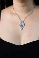 Ruby pentagon pendant shown worn on a model, with oxidized sterling silver texture and bold geometric shape.