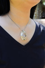 Madagascar Inclusion Quartz pendant worn on model as a polished sterling silver crystal necklace.