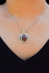 Ruby Cabochon sterling silver pendant shown worn on a model, with deep red oval stone and polished lunar silver setting.