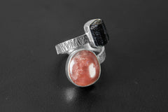 Close-up of Dravite Tourmaline and Sunstone ring on a dark background, showing high-shine silver and oxidized texture.