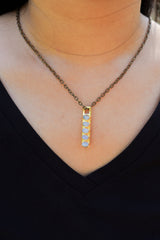 Blue Moonstone gold brass pendant worn as a long slim lunar talisman necklace.